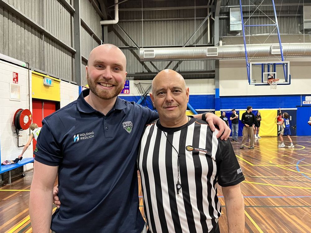 Head coach Cameron James on court with a referee